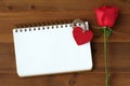 Red rose, fabric heart shape and blank note book paper on wood b Royalty Free Stock Photo