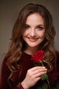 A red rose flower in the hands of a young beautiful smiling woman. Royalty Free Stock Photo