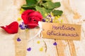 Greeting card with german text, Herzlichen Glueckwunsch, means congratulation with romantic red rose flower
