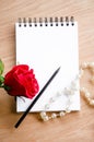 Red rose flower and pencil on blank diary. Royalty Free Stock Photo