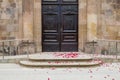 Red rose flower petals on the floor in front of the door of a church after a wedding. Divorce, settlement marriage sad concept Royalty Free Stock Photo