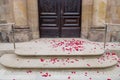 Red rose flower petals on the floor in front of the door of a church after a wedding. Divorce, settlement marriage sad concept. Royalty Free Stock Photo