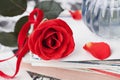 Red rose flower with a stack of postcard, retro photos and book