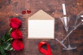 Red rose flowers bouquet, envelope and champagne glasses on wooden background. Valentine`s day greeting card Royalty Free Stock Photo