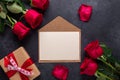 Red rose flowers bouquet, envelope, gift box on black stone background Valentine`s day greeting card Royalty Free Stock Photo