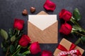 Red rose flowers bouquet, envelope, gift box, chocolate sweets on black stone background Valentine`s day greeting card Royalty Free Stock Photo