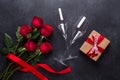Red rose flowers bouquet, gift box, champagne glasses on black stone background Valentine`s day greeting card Copy space Royalty Free Stock Photo