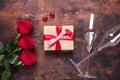 Red rose flowers bouquet, gift box and champagne glasses on wooden background Valentine`s day greeting card Royalty Free Stock Photo