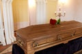 Red rose flowers on wooden coffin in church