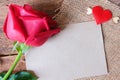Red rose with flying mini heart and brown paper card for Valentine's backdrop. Top view. Flat lay. Copy space