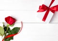 Red rose, gift with red ribbon on the white wooden background. Women`s day, mother day, valentines day, happy birthday Royalty Free Stock Photo