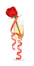 Red rose in glass of champagne and paper streamer. Royalty Free Stock Photo