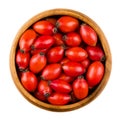 Red rose hips in a wooden bowl over white Royalty Free Stock Photo