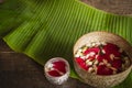 Red rose, Jasmine and popped rice on the calm water surface placed on the wood table Ready for pour water on the hands of revered Royalty Free Stock Photo