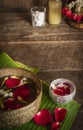 Red rose, Jasmine and popped rice on the calm water surface placed on the wood table Ready for pour water on the hands of revered Royalty Free Stock Photo