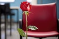 a red rose left on an empty office chair
