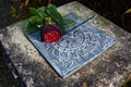 Red rose lying on a weathered sundial