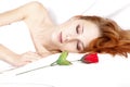 Red rose near pretty red-haired sleeping woman
