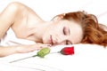 Red rose near pretty red-haired sleeping woman