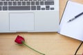 Red rose, notebook, pencil and laptop on wooden table for love c Royalty Free Stock Photo