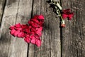 Red rose petal heart on aged wood table