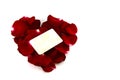 Red rose petals in a heart shape and old card isolated on white Royalty Free Stock Photo