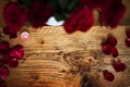 Red rose petals lit on rustic wood