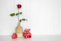 a red rose and a present box