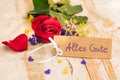 Red rose with tag with german text, Alles Gute, means all the best