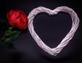 A red rose and a white heart made of wood on a dark background. Royalty Free Stock Photo