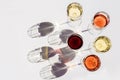 Red, rose and white wine top view in sunlight. Assorted wine in glass on white table. Dark shadows