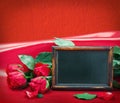 Red roses and blackboard with space for text Royalty Free Stock Photo
