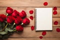 Red roses and blank notebook for Valentine Day on table