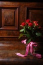 Red roses bouqet on the vintage old wooden piano Royalty Free Stock Photo