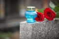 Red roses and candle on grey granite tombstone. Funeral ceremony Royalty Free Stock Photo