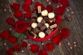 Red roses and chocolate pralines in heart shaped gift box Royalty Free Stock Photo