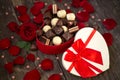 Red roses and chocolate pralines in red heart shaped gift box Royalty Free Stock Photo