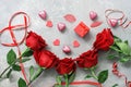 Red roses, chocolates heart, gift box and red ribbon on a gray concrete background. Valentine`s Day. Top view, flat lay Royalty Free Stock Photo