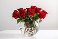 red roses in clear vase on white background
