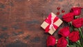 Red roses, gift box and decorative hearts on wooden background. Valentine`s day horizontal banner Royalty Free Stock Photo