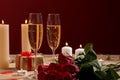 Red roses with gift and glasses of champagne on table. Valentines Day celebration Royalty Free Stock Photo