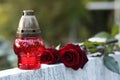 Red roses and grave lantern on tombstone outdoors, space for text. Funeral ceremony Royalty Free Stock Photo