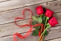 Red roses and heart shape ribbon over wood Royalty Free Stock Photo