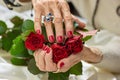 Red roses in old woman hands.