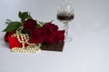 Red roses, pearl beads, glass of red wine, sweets Royalty Free Stock Photo