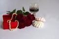 Red roses, pearl beads, glass of red wine, sweets Royalty Free Stock Photo