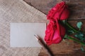 Red roses and pencil on wooden floor for Valentine& x27;s concept. Paper note for text