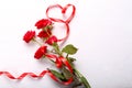 Red roses and ribbon on table