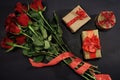 Red roses and three presents with red ribbon on black