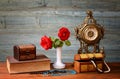 Red roses in a vase, clock and jewelry Royalty Free Stock Photo